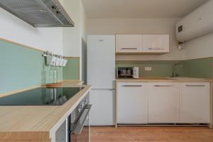 a kitchen with white cabinets and a counter top at R'Apparts T4 Les Balcons De Belledonne in Rhut +12 photos