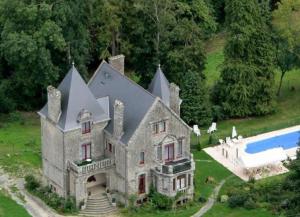 an old house with a swimming pool in front of it at Gite La Renardière in Langoëlan