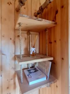 a shelf in a wooden wall with a toy swing at Le Chalet Du Blanc Spa yoga in Aillon-le-Jeune