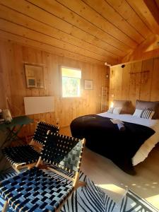 ein Schlafzimmer mit einem Bett in einer Holzhütte in der Unterkunft Le Chalet Du Blanc Spa yoga in Aillon-le-Jeune