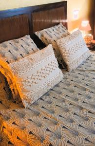 uma cama com duas almofadas em cima em La Maison des Poulains em Sauzon