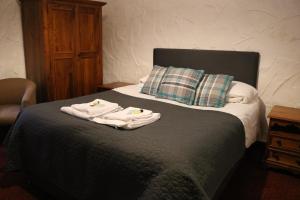 ein Schlafzimmer mit einem Bett mit Handtüchern darauf in der Unterkunft Black Dog Inn in Bolton