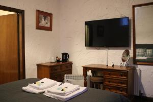 a hotel room with a bed with towels and a television at Black Dog Inn in Bolton