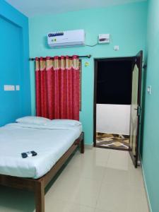 a room with two beds and a red curtain at ‌‌Florence guest house in Puducherry