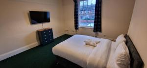 Habitación de hotel con cama y TV en ROOMS in WAKEFIELD CITY CENTRE en Wakefield