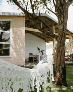 een witte hangmat aan een boom voor een huis bij Stylish Shack Falcon Bay in Wannanup