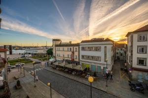 a city street with buildings and a sunset in the background at Casa Guerreiro - Regina Hotel Group in Viana do Castelo