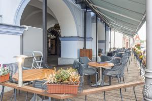 una fila de mesas y sillas en un patio en Hotel Zlatá Včela en Domažlice