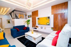 a living room with white furniture and a blue couch at Frotech property in Lekki