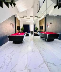 a pool room with two red pool tables in it at Frotech property in Lekki