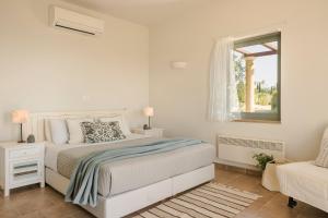 ケファロニアにあるAbsolute Villa by Stylish Staysの白いベッドルーム(ベッド1台、窓付)
