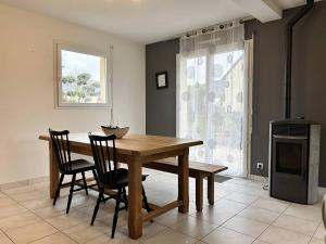 - une salle à manger avec une table et des chaises en bois dans l'établissement 956 - Maison 6p, à 15min du Val-André et d'Erquy., à Hénansal