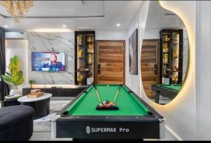 a living room with a pool table and a tv at Frotech property in Lekki