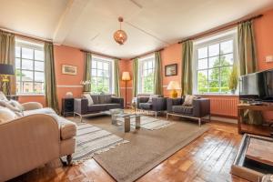 a living room with couches and a tv at The East Wing BB in Wymondham