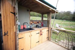 an outdoor kitchen with a sink in a cabin at Black Pig Retreats Luxury Glamping in Shaftesbury