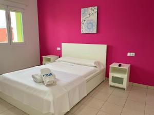 sypialnia z białym łóżkiem i różową ścianą w obiekcie Apartamento Pueblo Cid w mieście El Verger +8 zdjęć