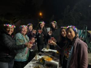 eine Gruppe von Frauen, die um einen Tisch mit Weingläsern stehen in der Unterkunft Bonita casa con vista al mar Las Cruces El Tabo in Las Cruces