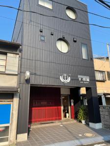 een gebouw met een rode en zwarte gevel bij 日月庵 BnB Sunmoon in Kanazawa