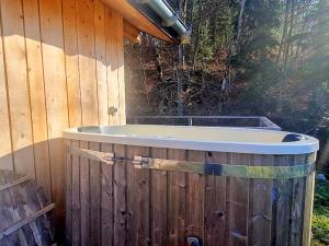 d'une baignoire installée à côté d'une clôture en bois. dans l'établissement Le Chalet Du Blanc Spa yoga, à Aillon-le-Jeune