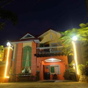 uma casa com varanda à noite com luzes em The Orange House - Vigan Villa em Vigan