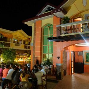 grupa ludzi siedzących w nocy przed restauracją w obiekcie The Orange House - Vigan Villa w mieście Vigan