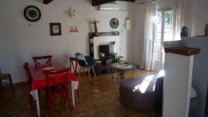 een woonkamer met een tafel en stoelen en een open haard bij Mas Maurane - Le Bougainvillier aux portes d'ARLES in Tarascon