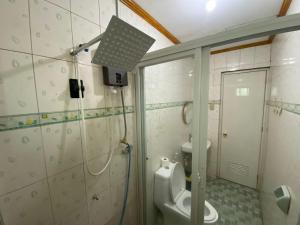 a bathroom with a toilet and a shower in it at The Orange House - Vigan Villa in Vigan +91 photos
