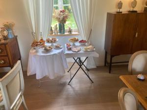 - une table avec de la nourriture dans une chambre avec une fenêtre dans l'établissement Le Manoir du Ribardon, à Neuvy-au-Houlme