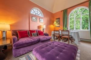 a living room with a purple couch and a table at The Gate House BB in Wymondham