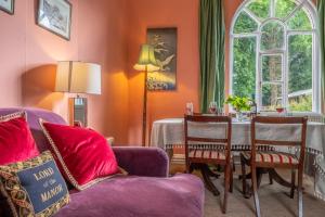 sala de estar con sofá púrpura y mesa en The Gate House BB, en Wymondham