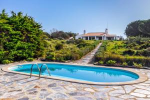 a swimming pool in a yard with a house in the background at Casa do Mar in Sesimbra