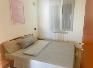 a large bed in a room with a window at Bella Vista Poggi 180Grad fantastischer Meerblick in Poggi