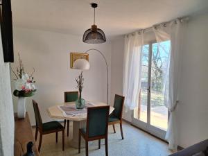 ein Esszimmer mit einem Tisch, Stühlen und einem Fenster in der Unterkunft La Bastide des Cades in Aiguines