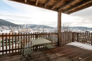 a table and chairs on a deck with a view at K1, appartement avec grande terrasse et vue pistes in Gérardmer