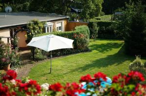 a white umbrella in the yard of a house at Ferienwohnung Am Fenn in Potsdam