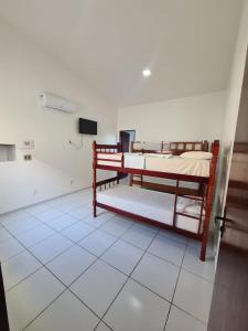 a room with two bunk beds on a tiled floor at POUSADA MARINHA DO CEU in Maceió
