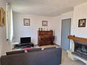 ein Wohnzimmer mit einem Sofa und einem Kamin in der Unterkunft La Bastide des Cades in Aiguines