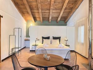 MontagutにあるCan Riera de Montagut - Masia per 20 personesのベッドルーム1室(ベッド1台、テーブル2台、椅子付)