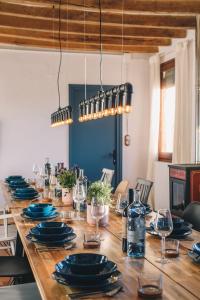 długi drewniany stół z niebieskimi płytami i okularami w obiekcie Can Riera de Montagut - Masia per 20 persones w mieście Montagut