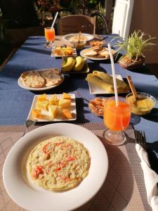 einen Tisch mit Teller mit Speisen und Orangensaft in der Unterkunft Goalma Family Holiday Resort & Restaurant in Anuradhapura