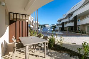 een tafel en stoelen op het balkon van een gebouw bij Residence Baia Bianca in Lido di Jesolo