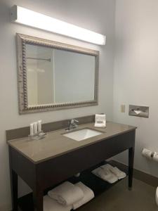 a bathroom with a sink and a mirror at Sonesta Essential IAH Airport JFK Boulevard - Newly Renovated in Houston