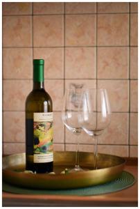 butelkę wina i dwa kieliszki wina na talerzu w obiekcie Color 24 Apartament V w mieście Stalowa Wola