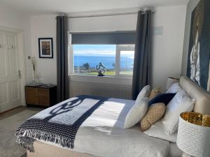 a bedroom with a bed and a window with a view at Follies Suites Ballyvoile in Dungarvan