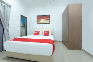 una camera da letto con un grande letto bianco con cuscini rossi di Sg Rengit City Resort 1 a Kampung Sungai Rengit