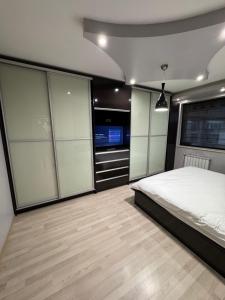 um quarto com uma cama grande e uma televisão em Апартамент БМ em Vratsa