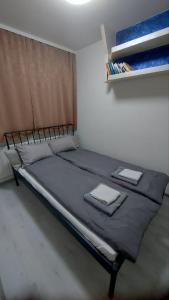 a bed in a room with two towels on it at Apartman Gold in Tuzla