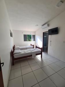 1 Schlafzimmer mit 2 Betten und einem Flachbild-TV in der Unterkunft POUSADA MARINHA DO CEU in Maceió