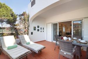 een patio met stoelen en een tafel bij Bia in Almancil
