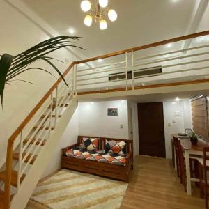 a living room with a couch under a staircase at The River House - Loft Unit - Vigan in Vigan